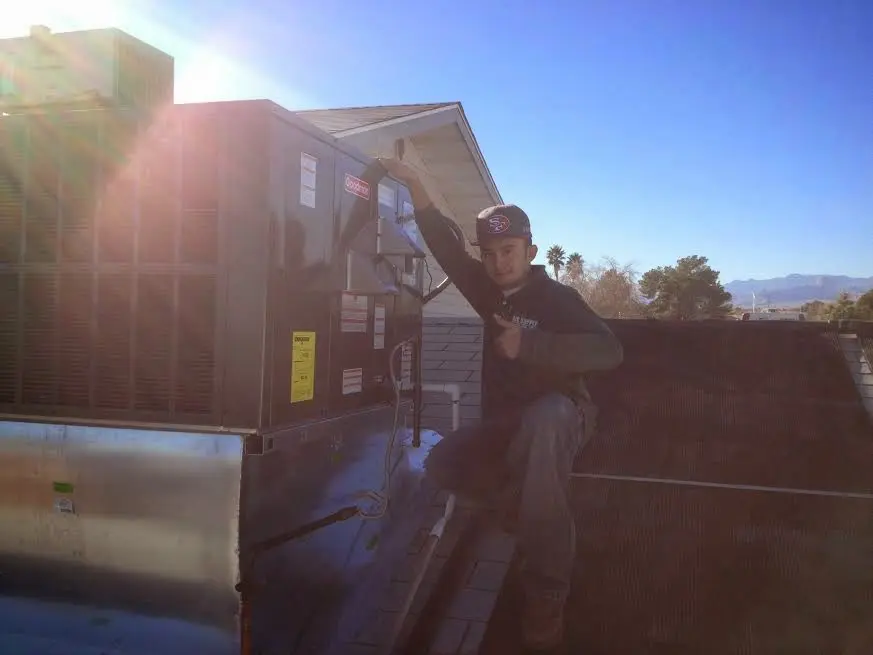 HVAC technician performing HVAC Inspection on a rooftop unit in Atmore